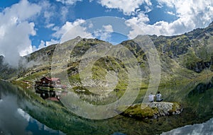 Balea lake and Balea Hotel in spring time with clouds